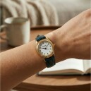 Montre &agrave; quartz ovale dor&eacute;e pour dame bracelet bleu au poignet